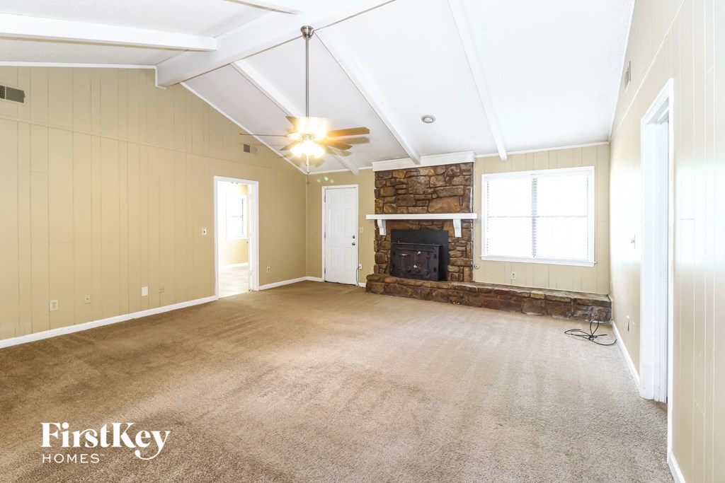 the living room of an empty house with a fireplace