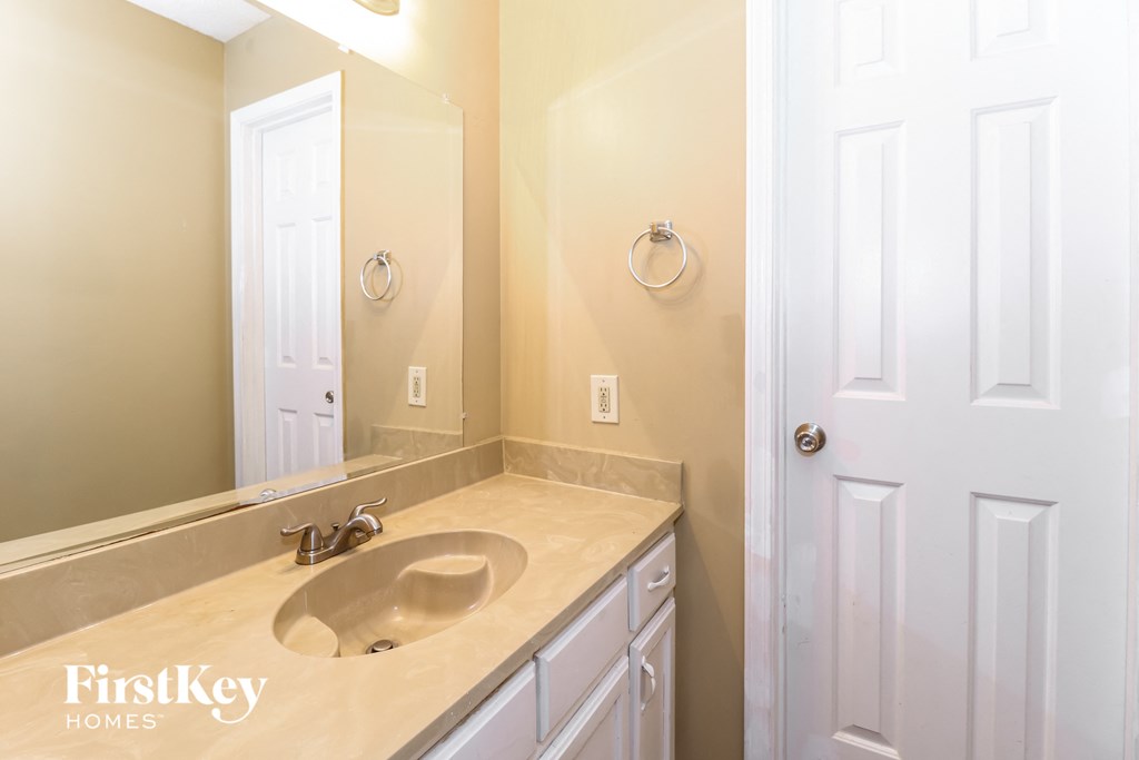 a bathroom with a sink and a mirror and a door