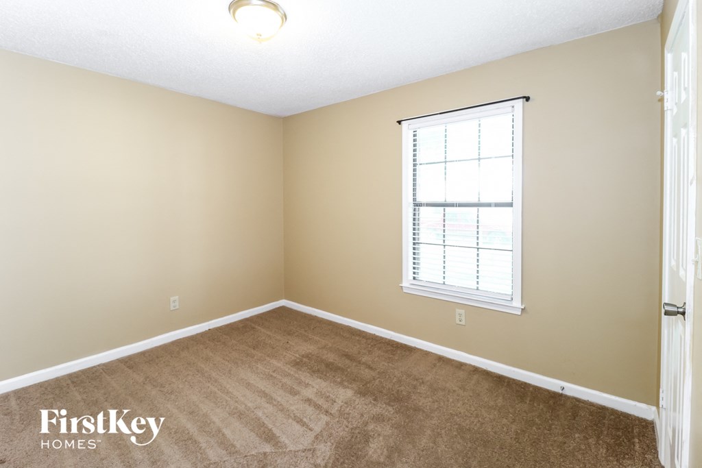 a bedroom with a carpeted floor and a window