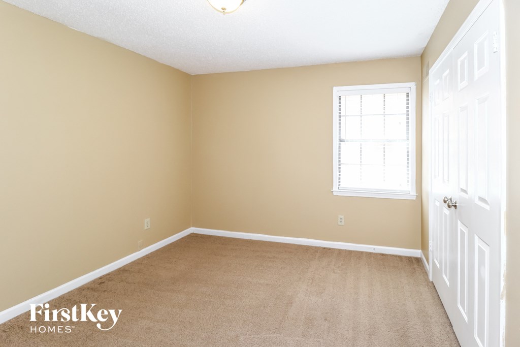 a bedroom with a carpeted floor and a window