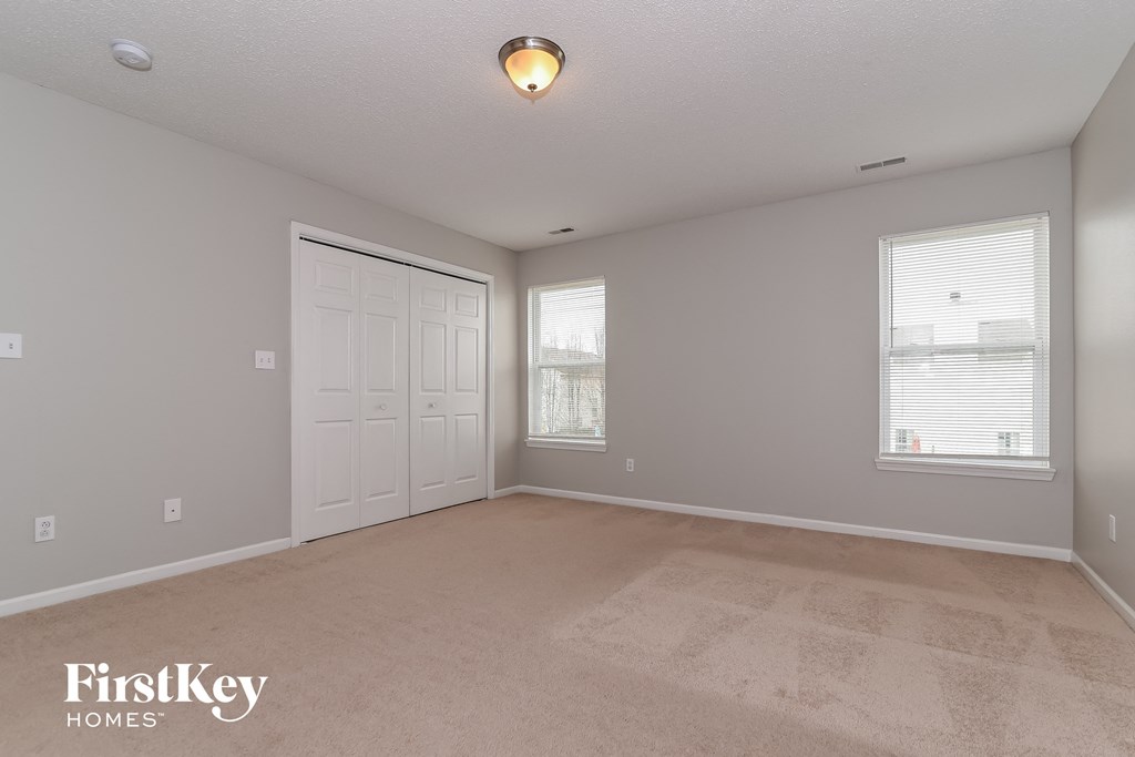 the living room of an empty house with a white door and window