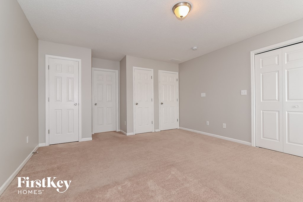 a bedroom with four doors and a carpeted floor