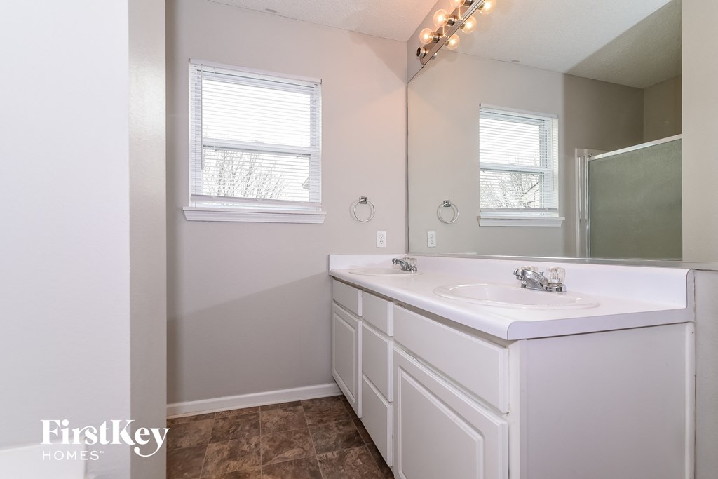 a bathroom with white cabinets and a sink and a mirror