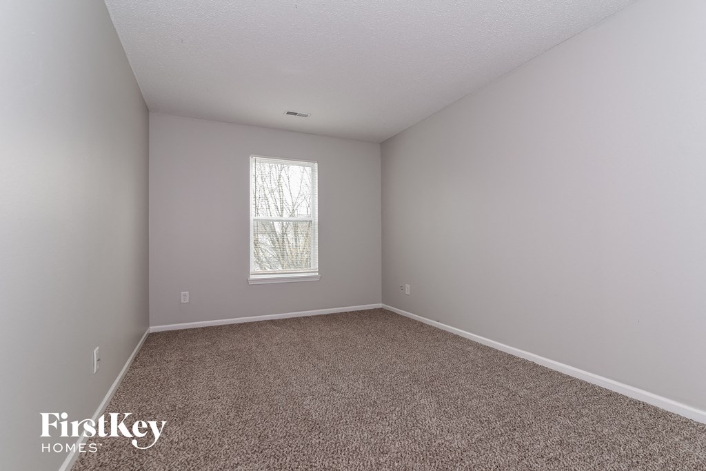 a bedroom with carpet and a window