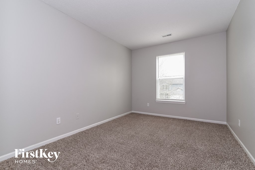 an empty room with carpet and a window