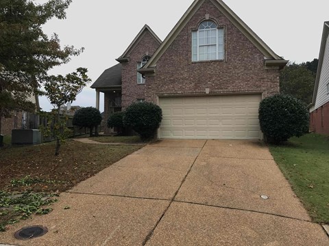 a driveway in front of a house with a garage door