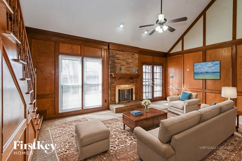A living room with a fireplace and a television on the wall.