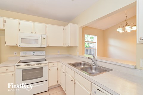 A kitchen with a stove, oven, microwave, and sink.