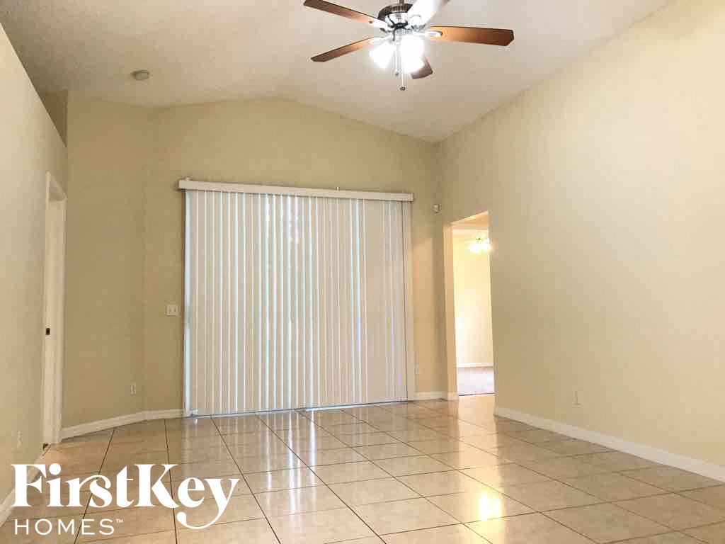 A room with a ceiling fan and a sliding door.