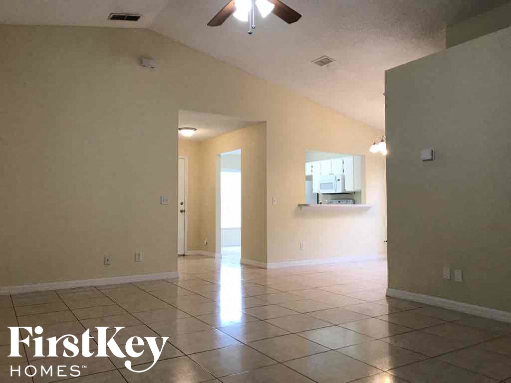 A spacious room with a tiled floor and a ceiling fan.