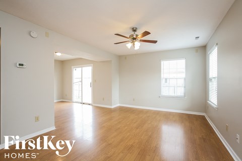 A spacious room with a ceiling fan and wooden flooring.