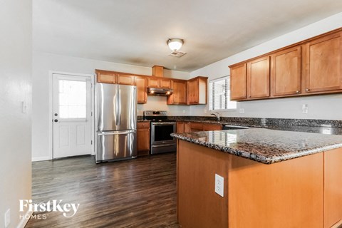 A kitchen with wooden cabinets and a granite countertop.
