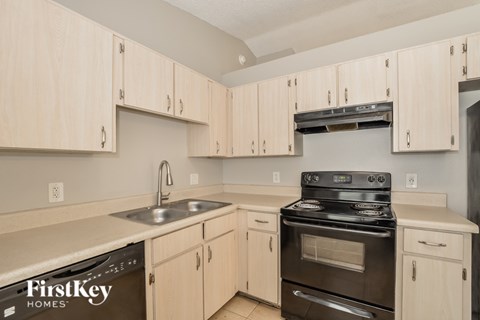 A kitchen with wooden cabinets and a stove top oven.