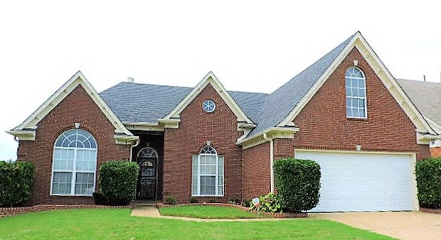 a red brick house with a white garage door