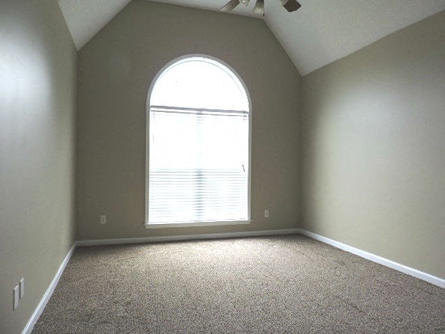 an empty room with a large window and carpet