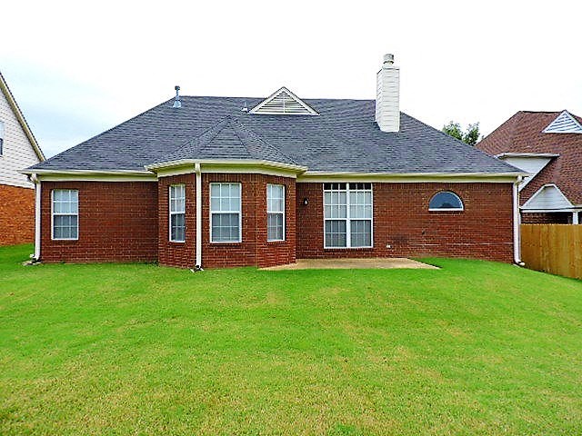 a red brick house with a green yard