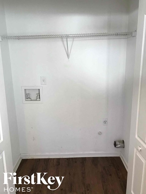 a small room with a white wall and a closet with a curtain