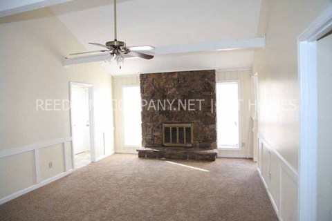 a living room with a fireplace and a ceiling fan