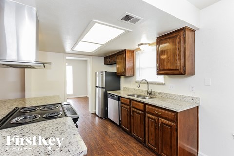 a kitchen with wood cabinets and granite counter tops and a stove and refrigerator