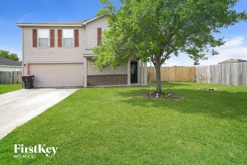 a house with a lawn and a tree in front of it