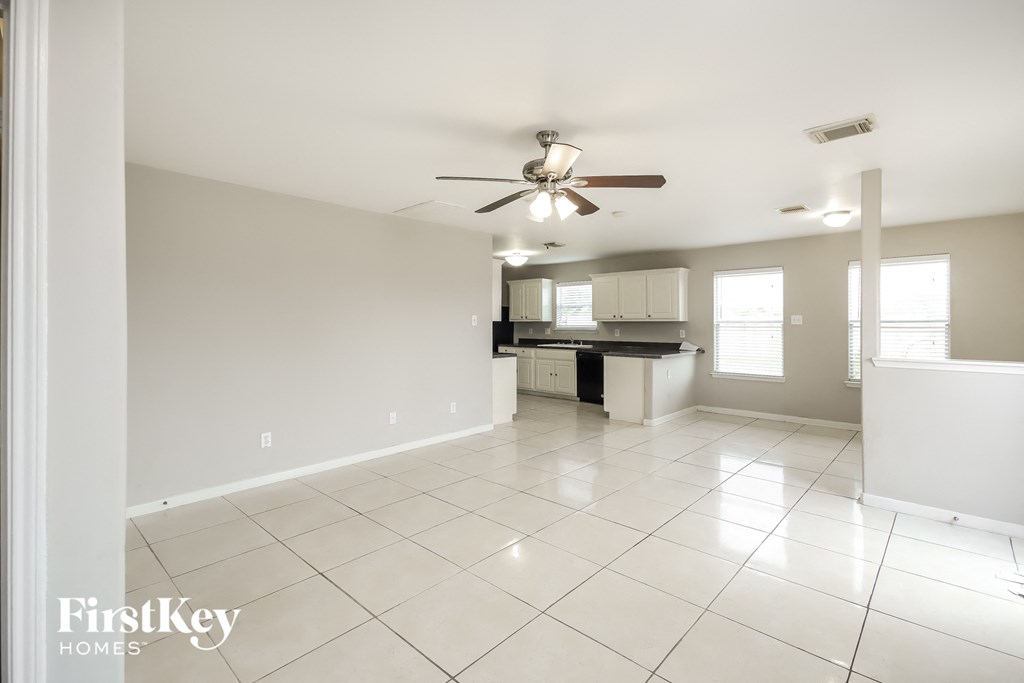 an empty kitchen and living room with a ceiling fan