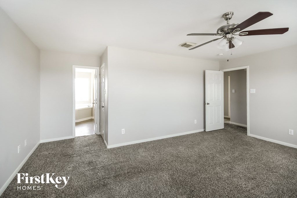 a living room with carpet and a ceiling fan