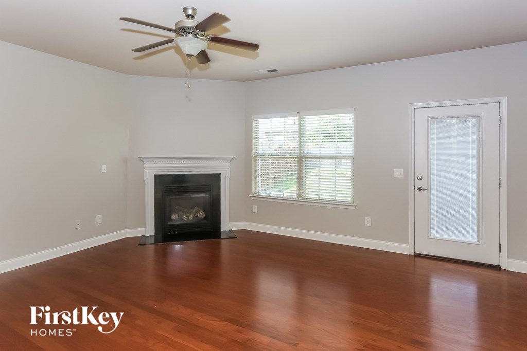 a living room with a fireplace and a ceiling fan