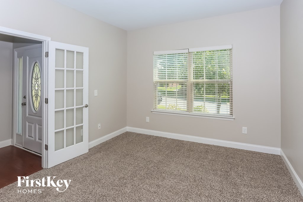 a room with carpet and a door and window