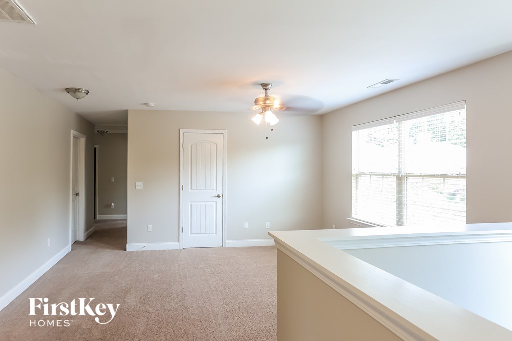 a master bedroom with a large window and a sink and a ceiling fan