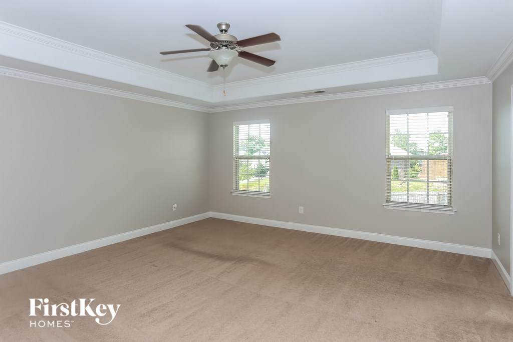 an empty room with a ceiling fan and a window