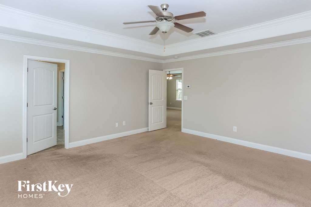 a living room with carpet and a ceiling fan
