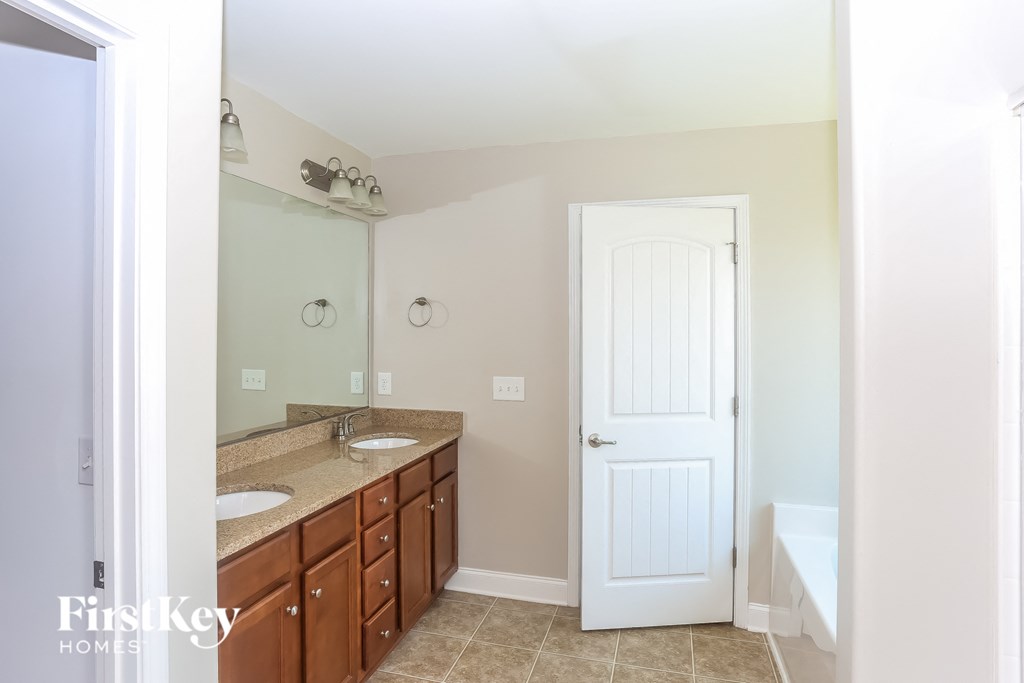 a bathroom with two sinks and a mirror and a white door