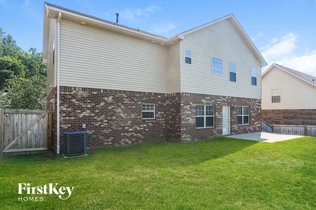 the back of a house with a yard and a fence