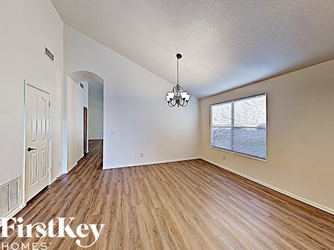 a spacious living room with hardwood flooring and a large window