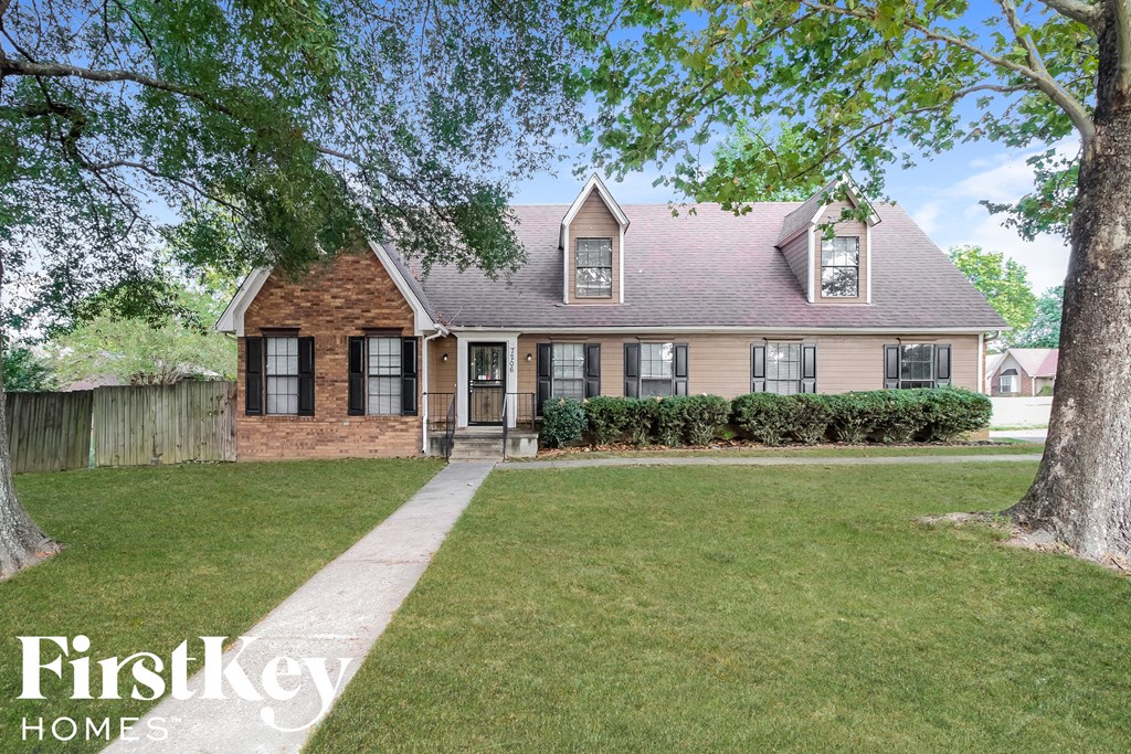 A house with a brick facade and a large front yard.
