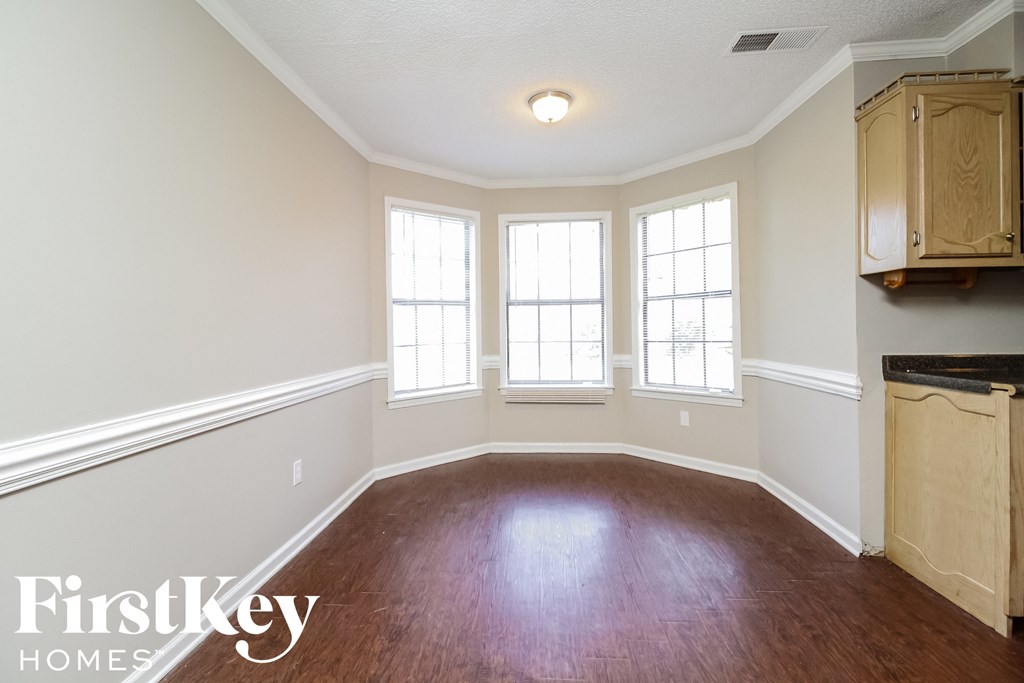 A room with wooden floors and a cabinet on the wall.
