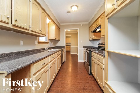 A kitchen with wooden cabinets and a granite countertop.