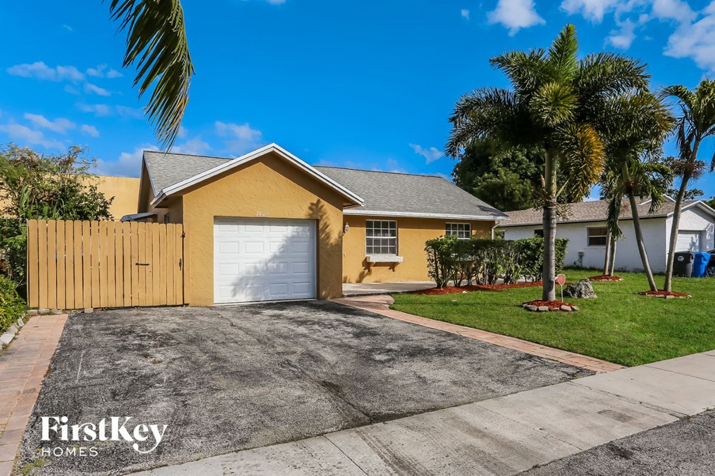 A yellow house with a garage door is for sale by FirstKey Homes.