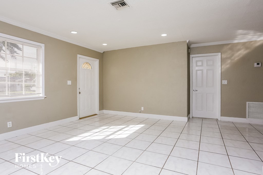 A room with a white tile floor and two white doors.