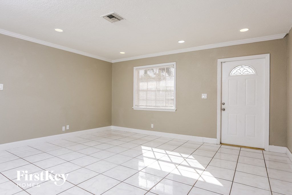 A room with a white door and a window with blinds.