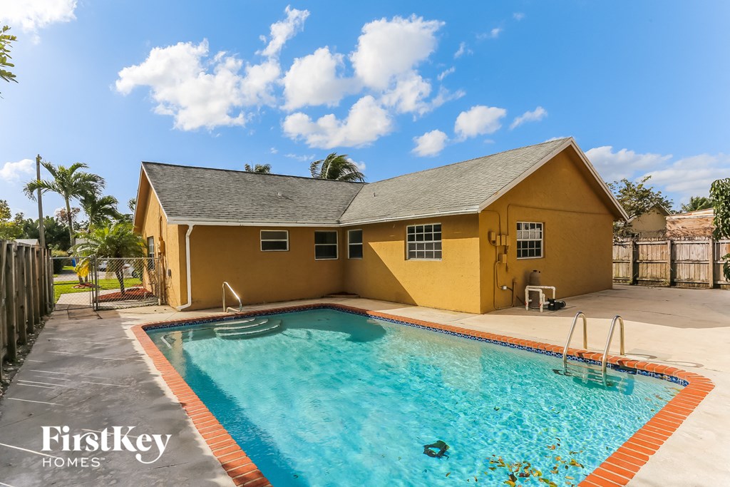 A yellow house with a pool in the foreground and the words "FirstKey Homes" on the bottom left.