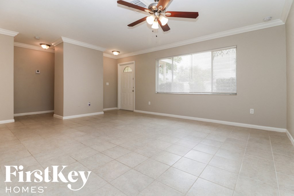 A spacious room with a ceiling fan and tiled floor.