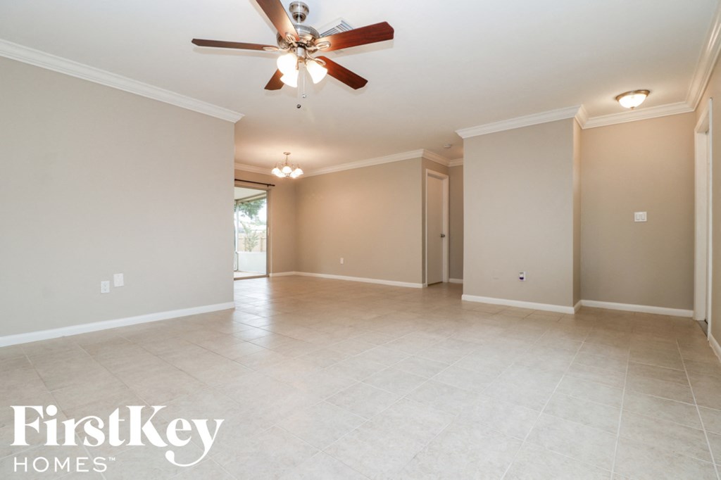 A spacious room with a ceiling fan and light fixture.