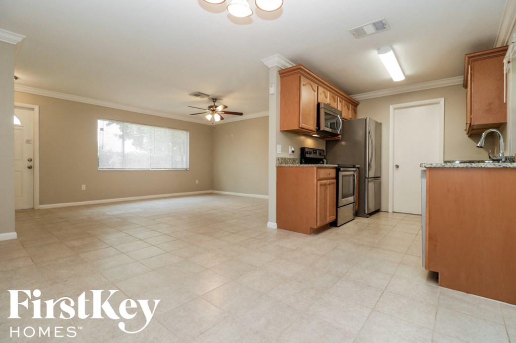 A kitchen with a refrigerator, microwave, and oven.