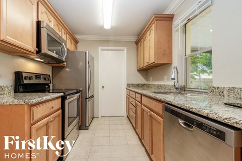 A kitchen with wooden cabinets and granite countertops.