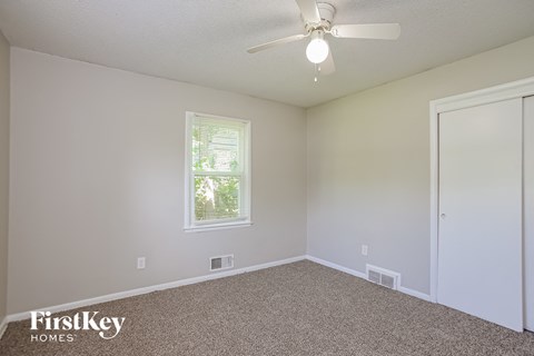 a bedroom with carpet and a ceiling fan