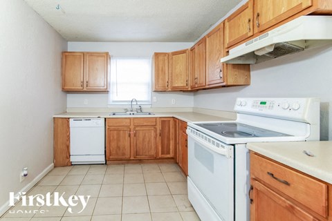 A kitchen with wooden cabinets and white appliances.