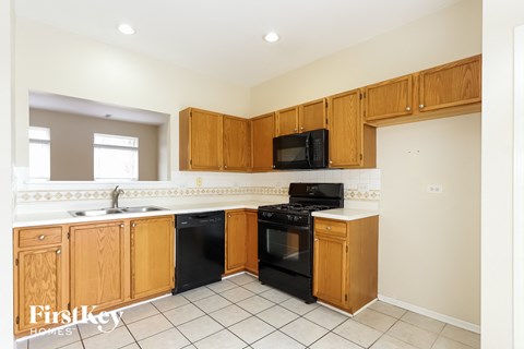 A kitchen with wooden cabinets and black appliances.