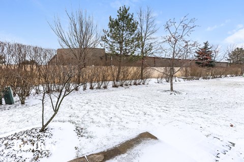 A snow-covered field with a large building in the background.