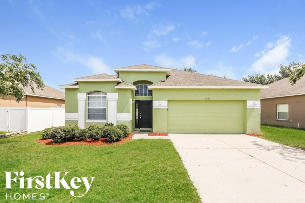 A house with a green front yard and a brown roof.